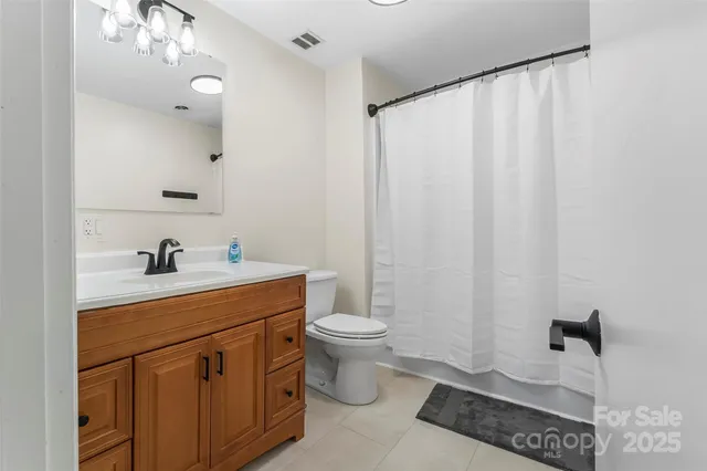 a bathroom with a sink a toilet and shower curtain