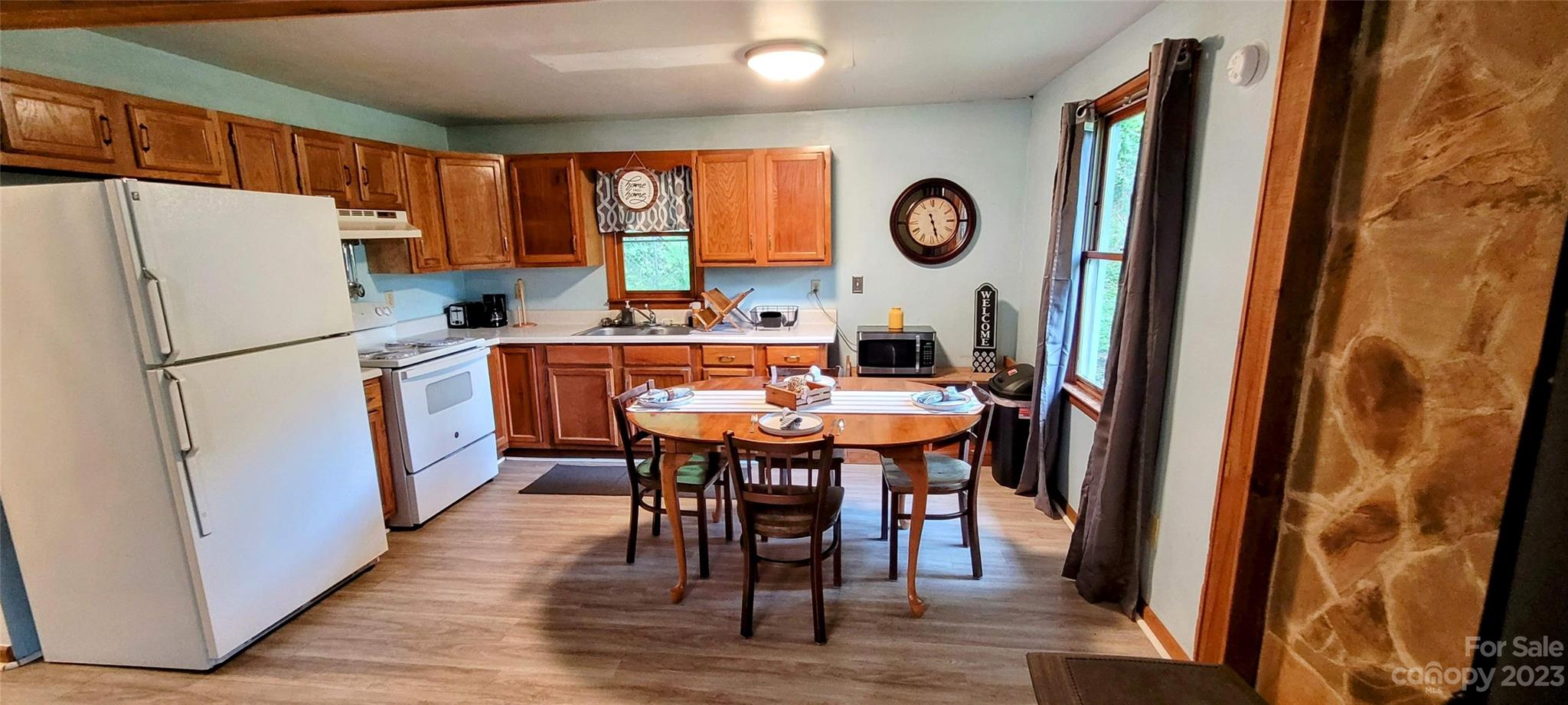 6115 Skyland Drive Sylva, NC 28779 - Photo 11 of 15 a kitchen with stainless steel appliances granite countertop a refrigerator a stove a sink and a dining table with wooden floor