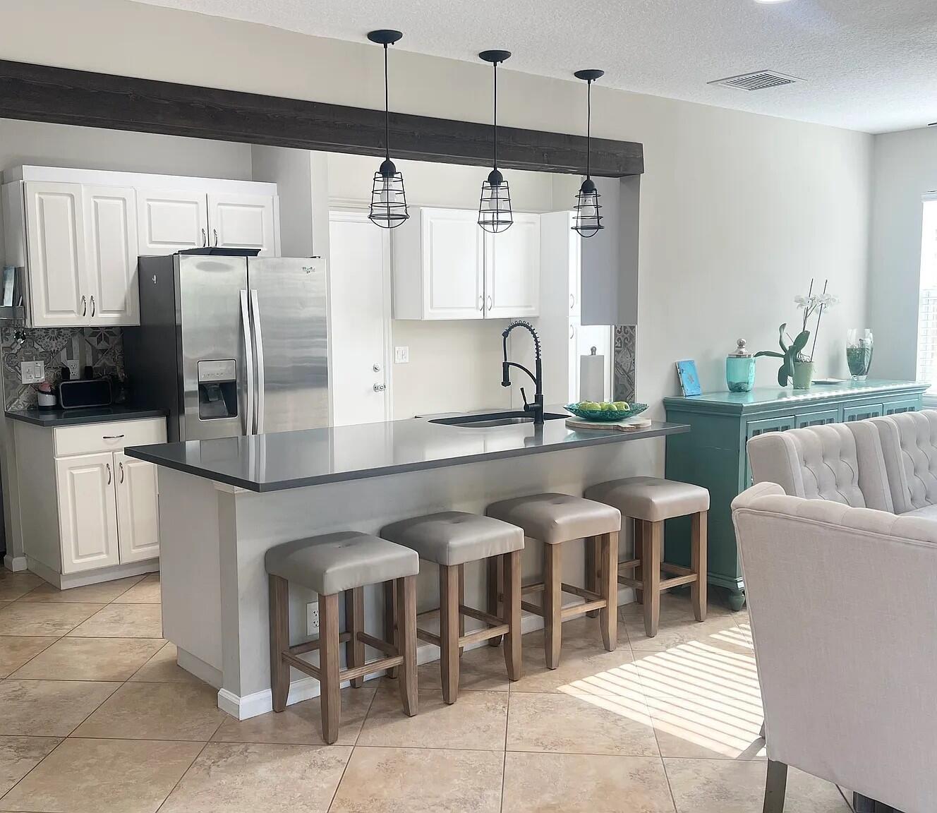 6435 Foster Street Jupiter, FL 33458 - Photo 3 of 8 a kitchen with granite countertop a sink stainless steel appliances and white cabinets