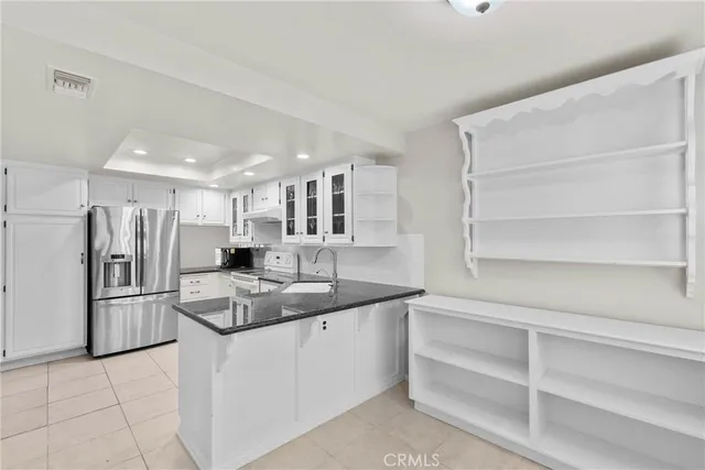 a kitchen with stainless steel appliances granite countertop a refrigerator and a sink