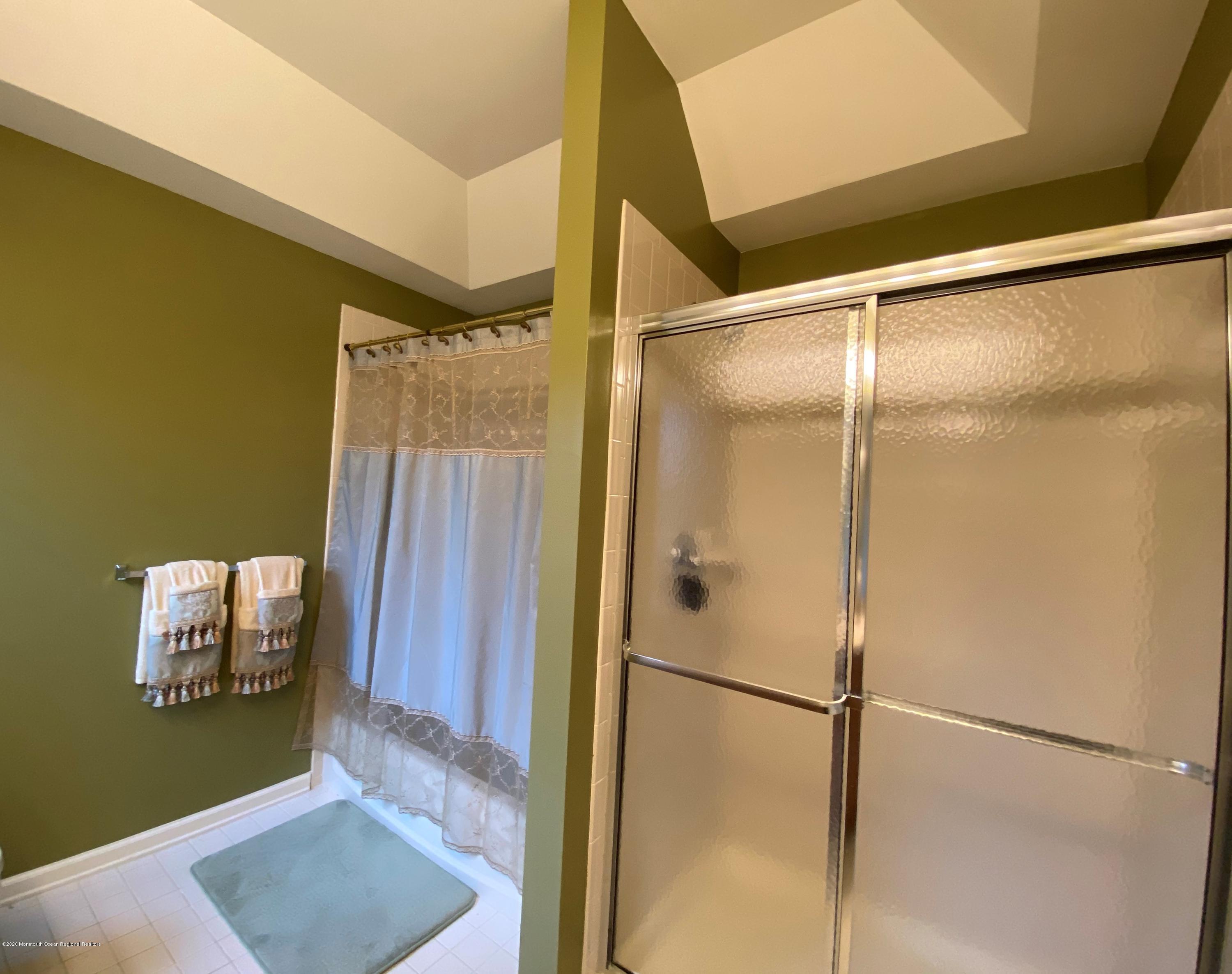 27 Northwoods Road Asbury Park, NJ 07712 - Photo 55 of 76 a bathroom with a glass shower door and a mirror