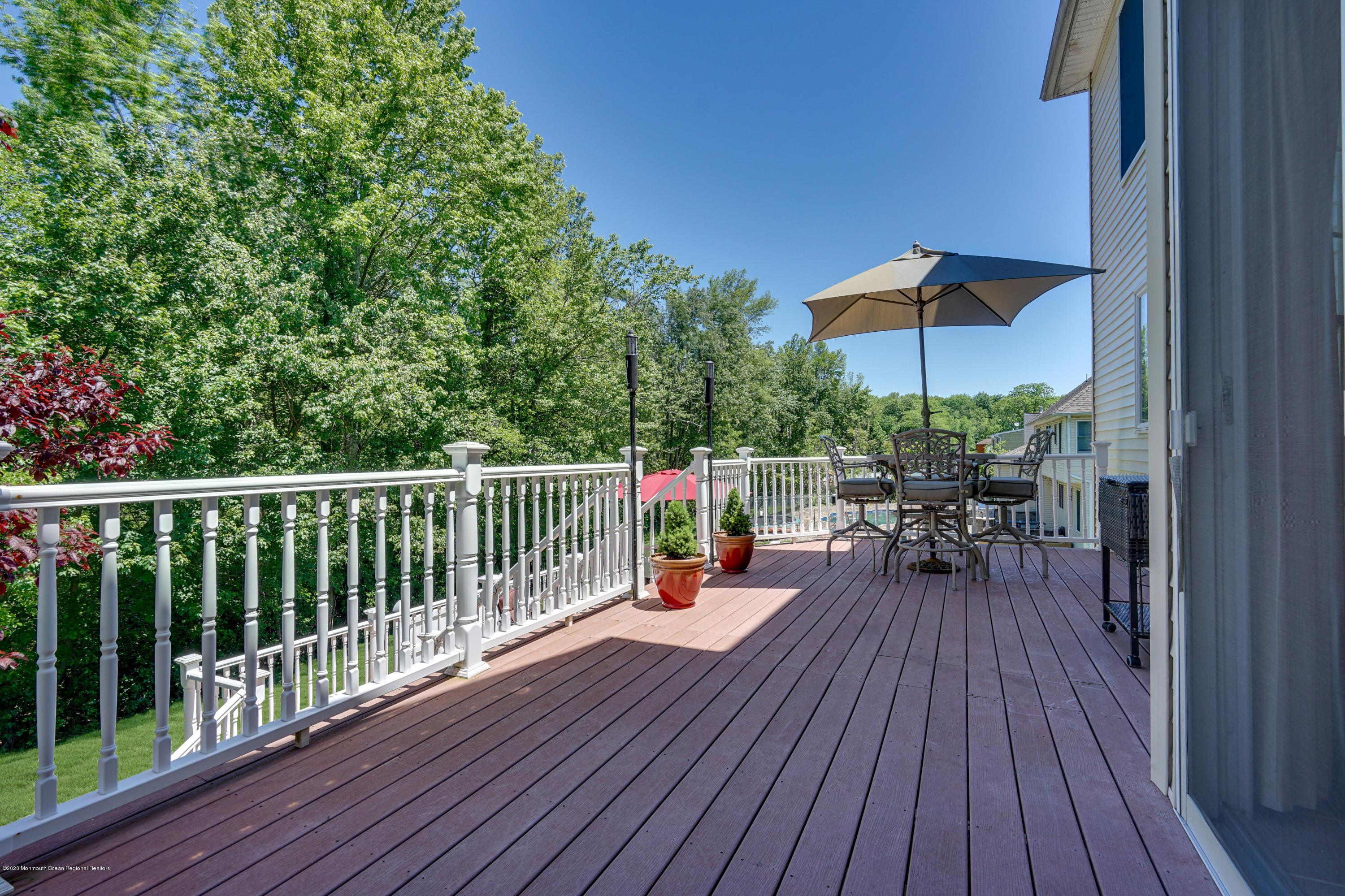 27 Northwoods Road Asbury Park, NJ 07712 - Photo 74 of 76 a view of a roof deck with a dining table and chairs with wooden floor