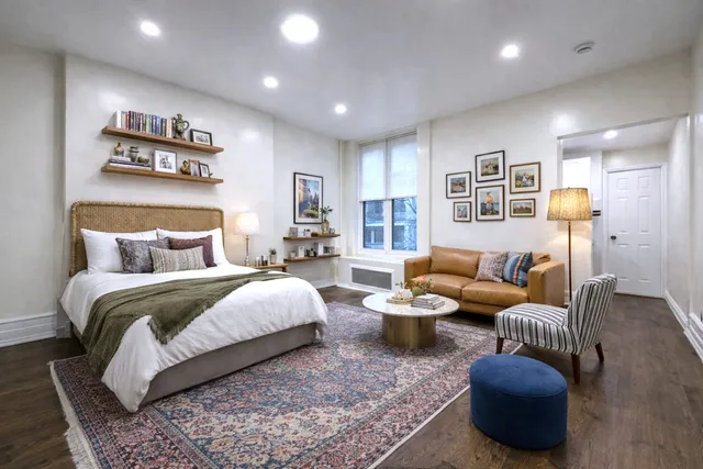 a spacious bedroom with a bed and glass top table