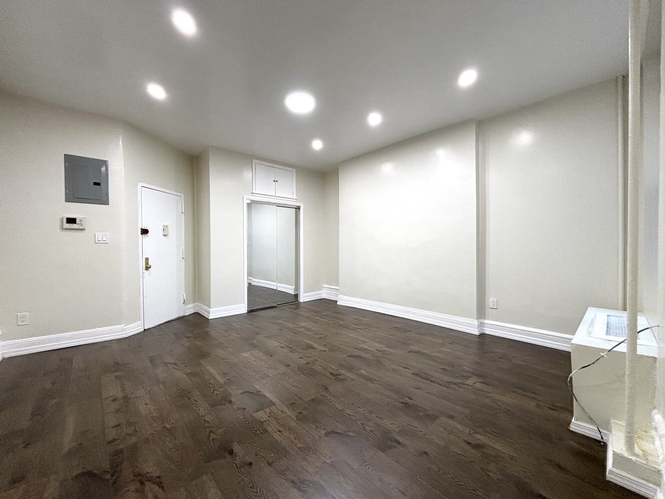511 West 142nd Street, Unit 5 Manhattan, NY 10031 - Photo 2 of 5 an empty room with wooden floor and windows