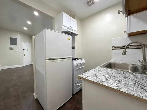 a kitchen with kitchen island a sink appliances and cabinets
