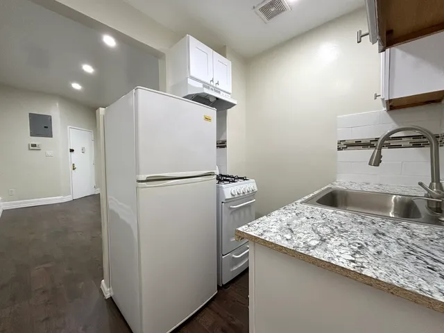 a kitchen with kitchen island a sink appliances and cabinets