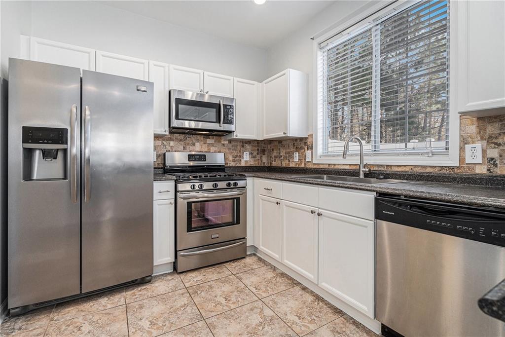 244 Windcroft Circle Northwest Acworth, GA 30101 - Photo 7 of 18 a kitchen with stainless steel appliances granite countertop a sink stove and refrigerator