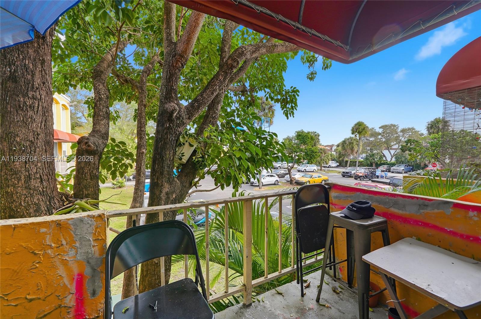 17901 Northwest 68th Avenue, Unit R206 Hialeah, FL 33015 - Photo 12 of 21 a balcony with wooden floor and outdoor seating