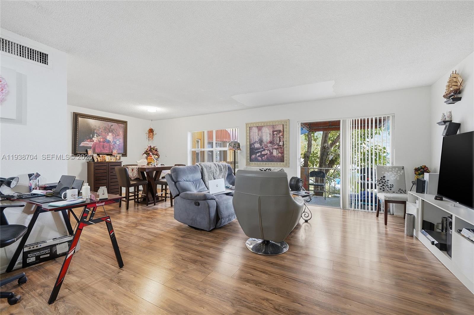 17901 Northwest 68th Avenue, Unit R206 Hialeah, FL 33015 - Photo 3 of 21 a living room with furniture flat screen tv and wooden floor