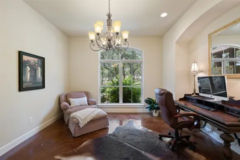 a living room with furniture piano and a chandelier