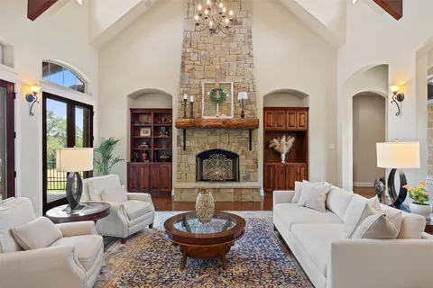 a living room with furniture a fireplace and a chandelier