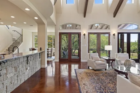 a living room with furniture large window and wooden floor