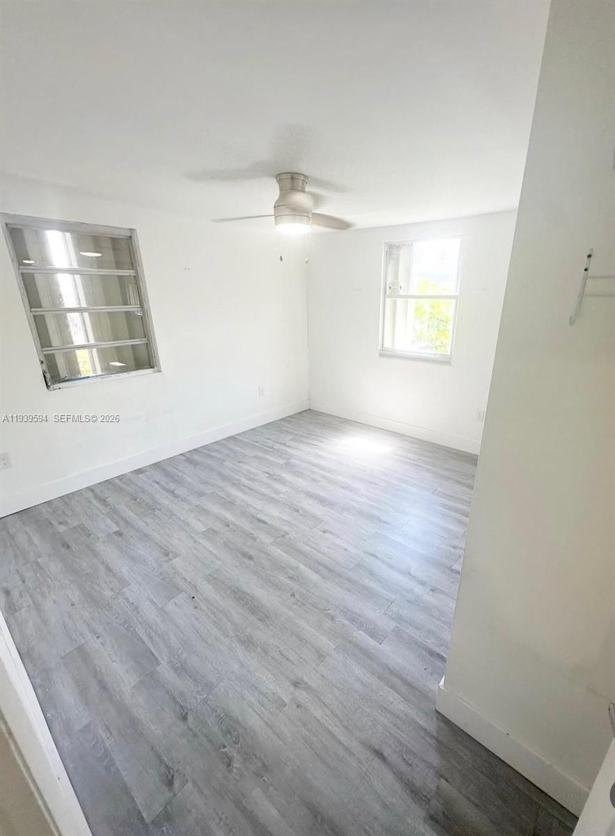 6537 Southwest 39th Terrace Miami, FL 33155 - Photo 13 of 22 an empty room with wooden floor and windows