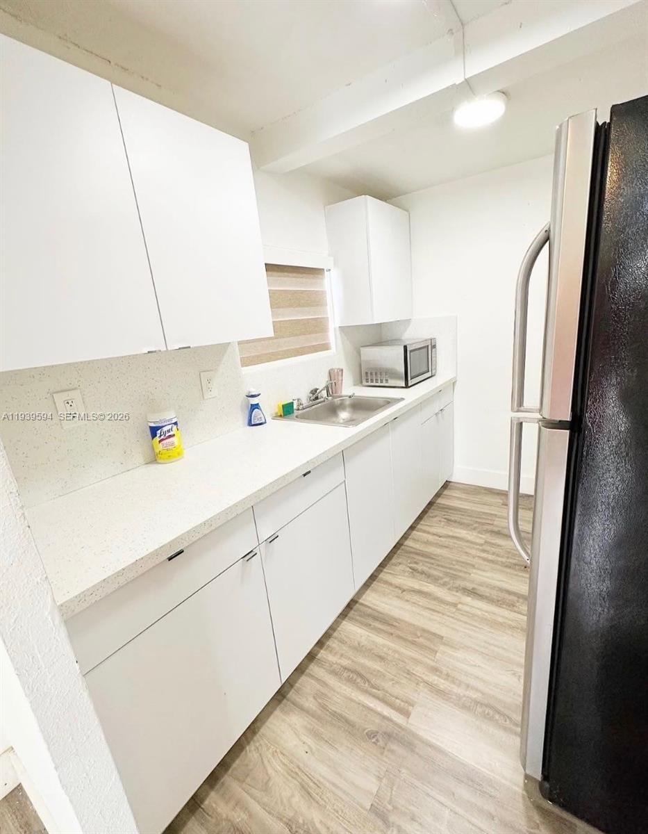 6537 Southwest 39th Terrace Miami, FL 33155 - Photo 18 of 22 a large white kitchen with a sink a refrigerator and a stove top oven