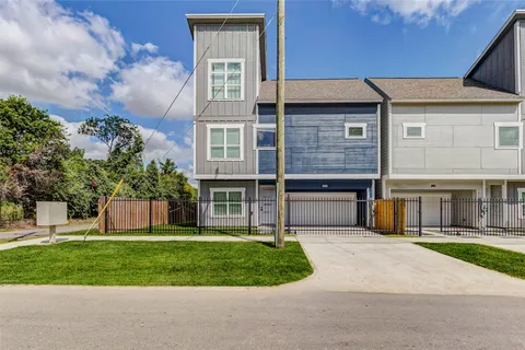 a front view of a house with a garden and yard