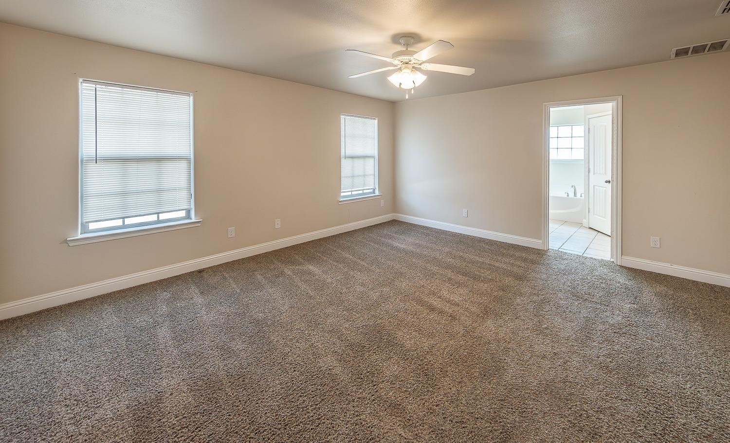 5504 110th Street Lubbock, TX 79424 - Photo 11 of 23 an empty room with windows and fan
