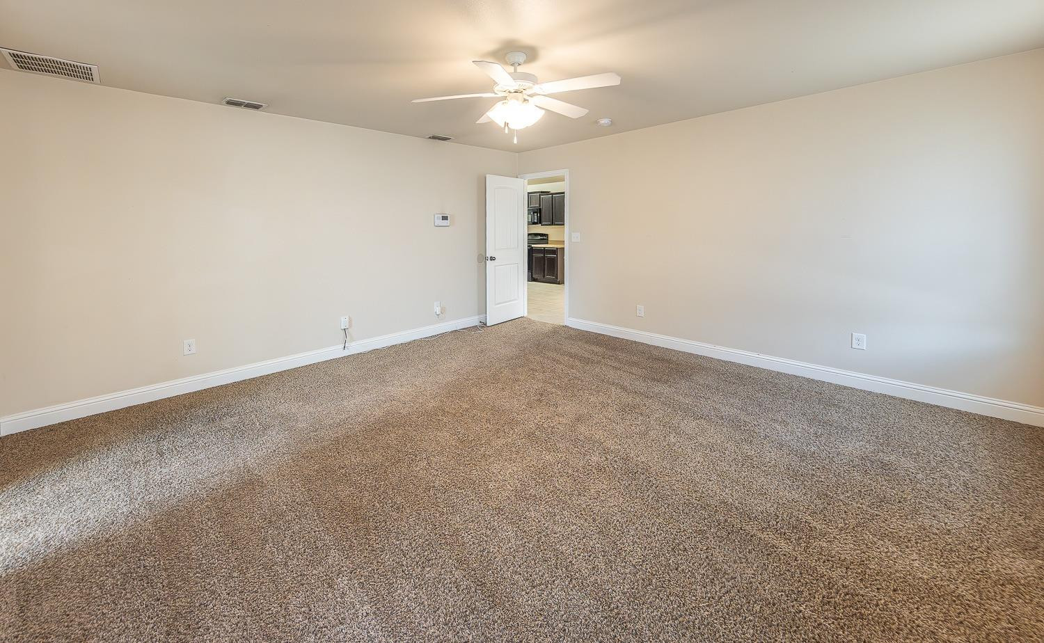 5504 110th Street Lubbock, TX 79424 - Photo 12 of 23 a view of an empty room with a ceiling fan and window