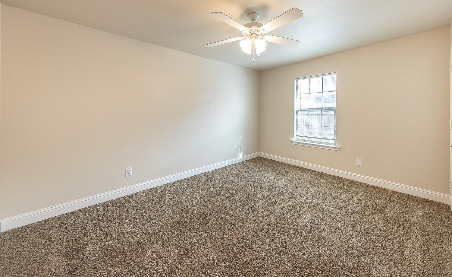 5504 110th Street Lubbock, TX 79424 - Photo 18 of 23 an empty room with a window and a fan