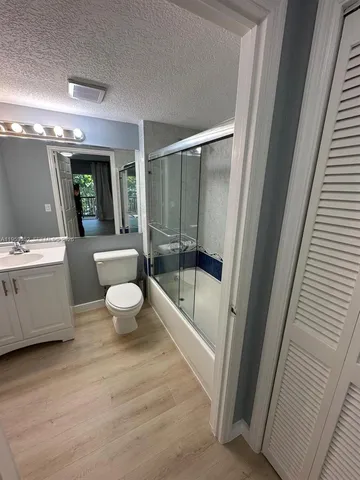 a bathroom with a bathtub shower sink mirror and toilet