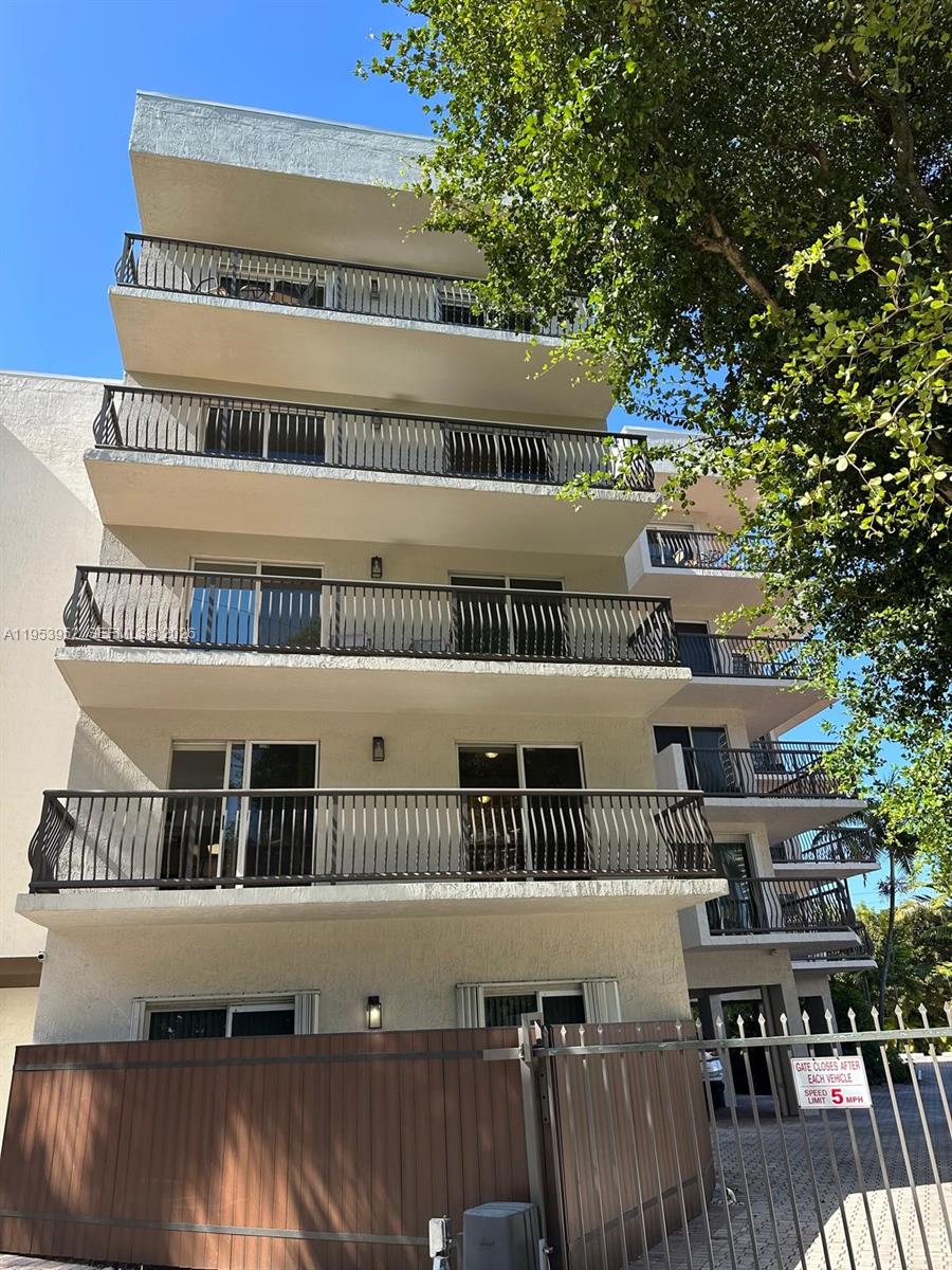 1918 Brickell Avenue, Unit 305 Miami, FL 33129 - Photo 2 of 17 a front view of a building with glass windows and iron fence