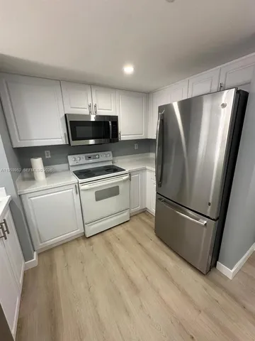 a kitchen with stainless steel appliances a refrigerator sink and microwave