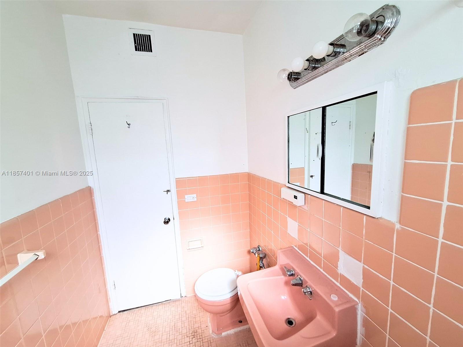 1770 Meridian Avenue, Unit 207 Miami Beach, FL 33139 - Photo 13 of 26 a bathroom with a sink mirror vanity and toilet