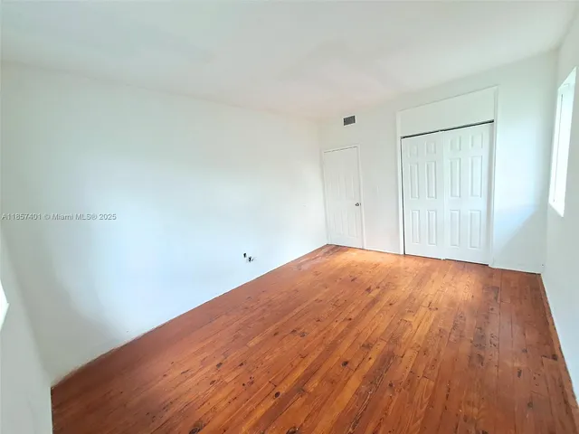 a view of an empty room and wooden floor