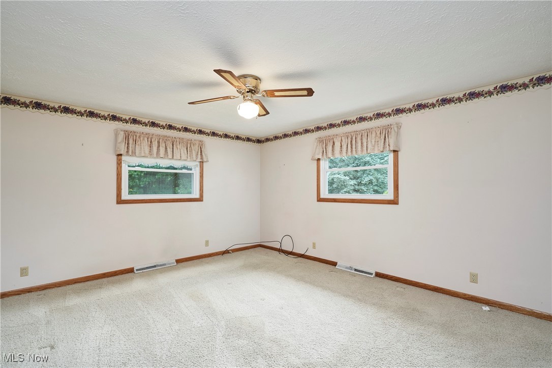 650 Rothrock Circle Akron, OH 44321 - Photo 24 of 31 Carpeted Master bedroom with healthy amount of natural light and ceiling fan