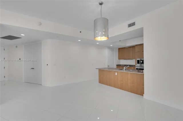 a kitchen with granite countertop a refrigerator and a stove top oven