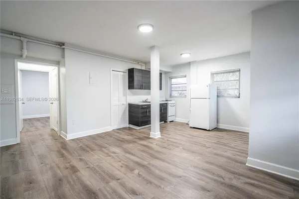 a view of a kitchen with a sink and a refrigerator