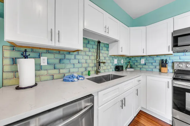 a kitchen with white cabinets and white appliances