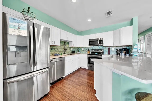 a kitchen with stainless steel appliances a refrigerator sink and microwave