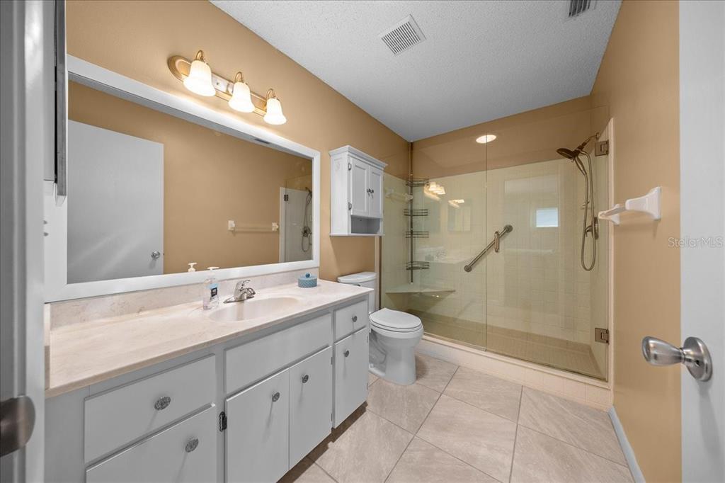8720 Southwest 90th Street, Unit A Ocala, FL 34481 - Photo 34 of 71 a bathroom with a double vanity sink toilet mirror and shower