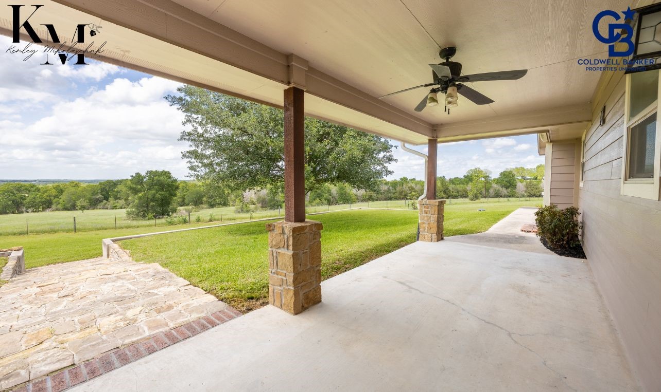 1980 Chappell Ridge Lane Brenham, TX 77833 - Photo 10 of 13 Inviting back porch overlooking the expansive acreage, offering a peaceful spot to relax, entertain, and take in the quiet country surroundings