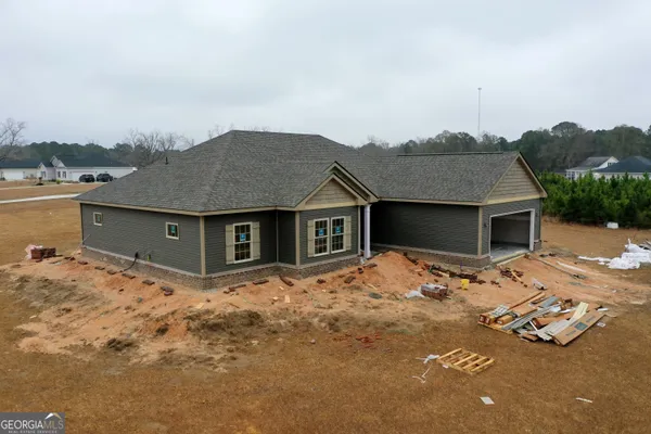 a view of a house with backyard and trees