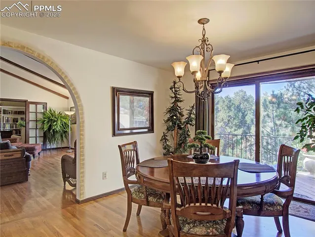 a view of a dining room with furniture a chandelier and wooden floor