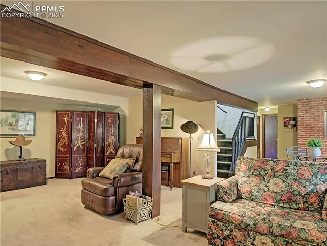 a living room with furniture fireplace and a large window