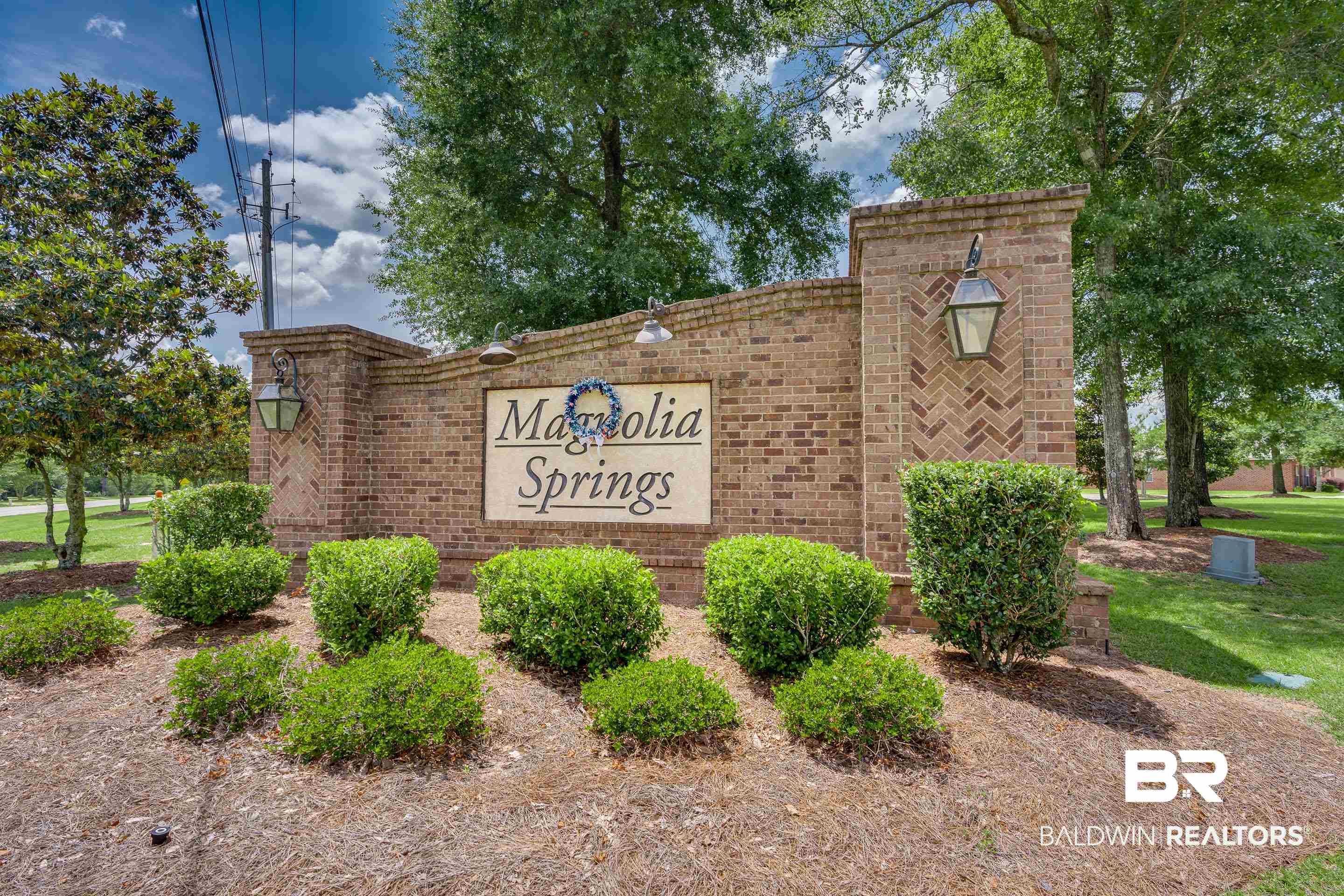 2215 Fernwood Loop West Semmes, AL 36575 - Photo 39 of 40 Brick entrance monument featuring an integrated sign, decorative lanterns, and established landscaping
