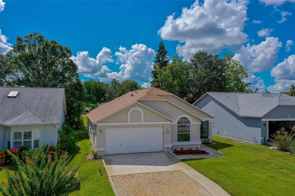 128 Crooked Pine Road Port Orange, FL 32128 - Photo 3 of 46 a front view of a house with a yard and garage