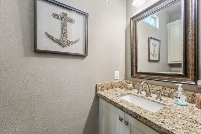 a en suite bathroom with a granite countertop sink and a mirror