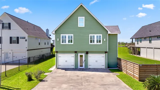 a front view of a house with a garden and garage
