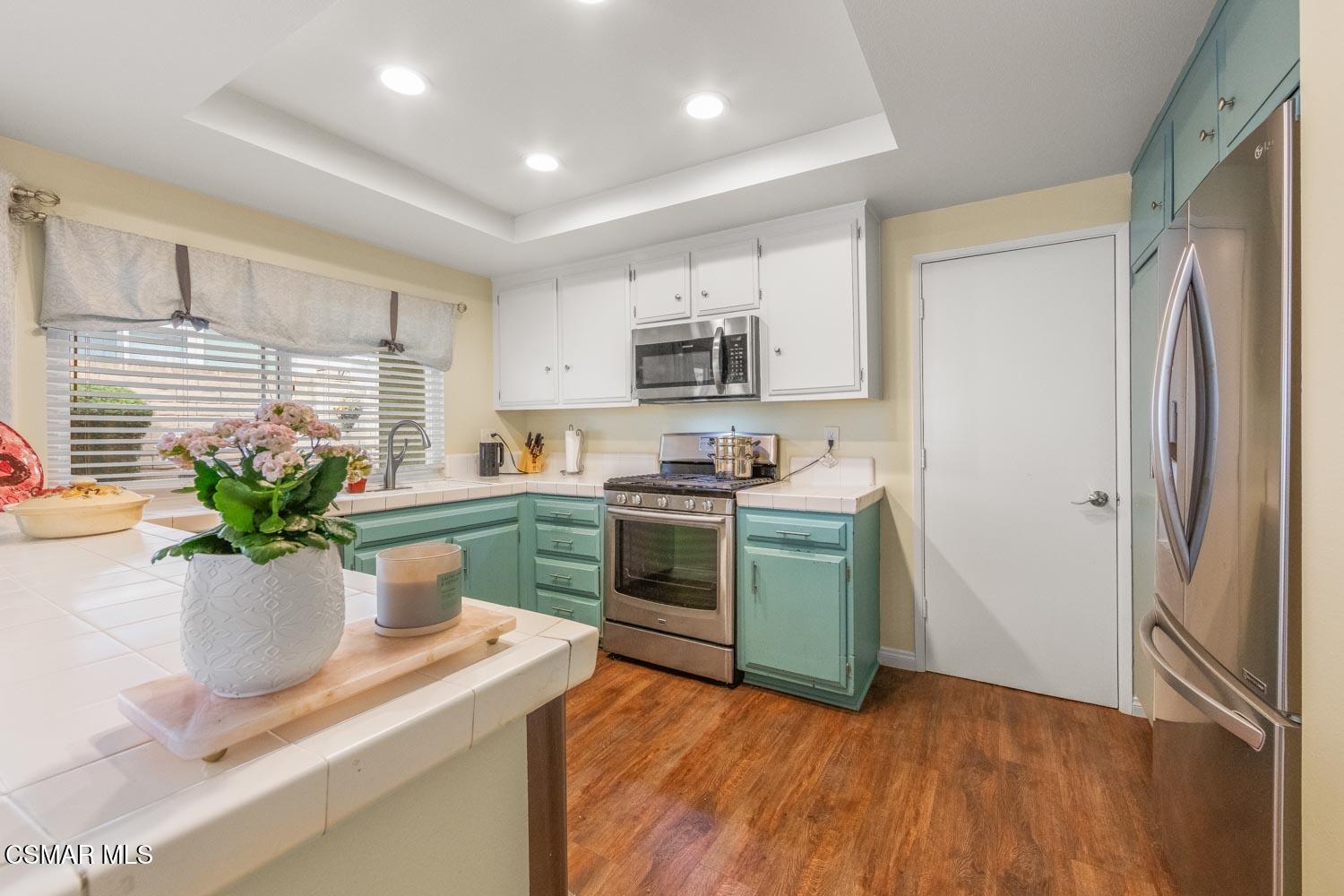 2413 Lita Place Simi Valley, CA 93063 - Photo 4 of 17 a kitchen with kitchen island stainless steel appliances a sink a stove and a window