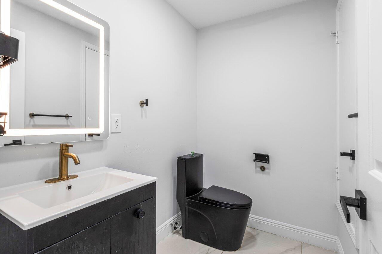 7748 Travelers Tree Drive Boca Raton, FL 33433 - Photo 14 of 35 a bathroom with a sink a toilet and mirror
