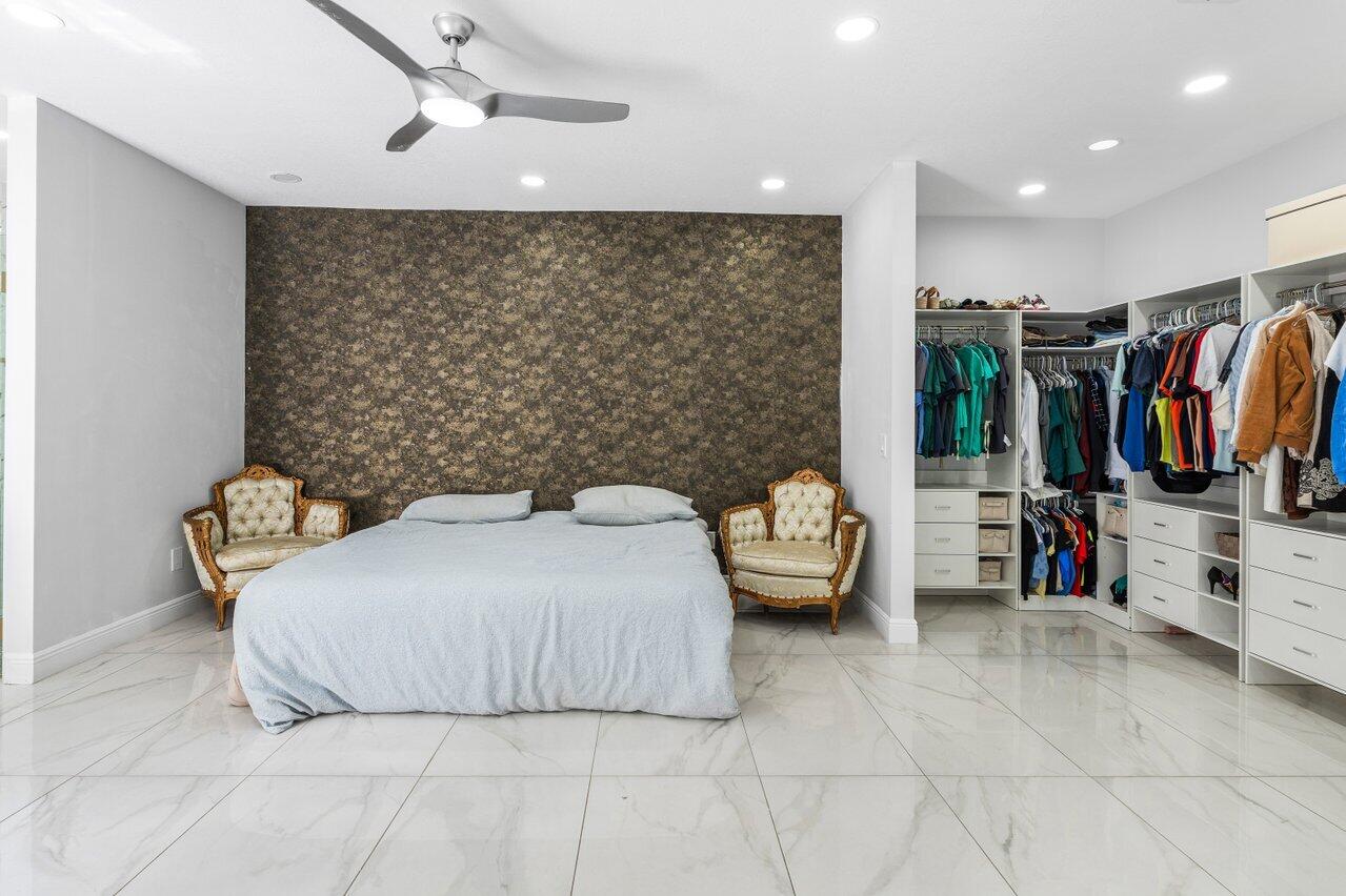 7748 Travelers Tree Drive Boca Raton, FL 33433 - Photo 15 of 35 a bedroom with a bed and a walk in closet