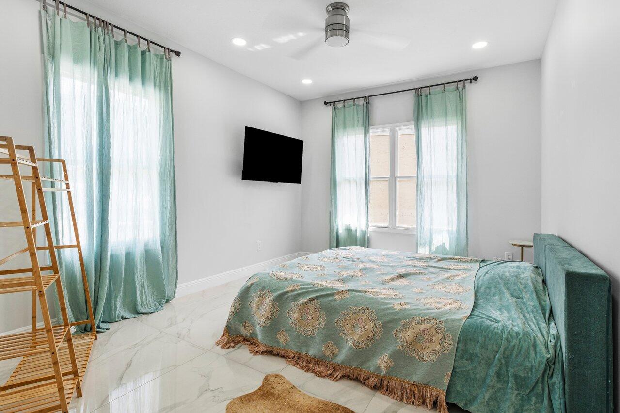 7748 Travelers Tree Drive Boca Raton, FL 33433 - Photo 20 of 35 a bedroom with a bed and a flat screen tv