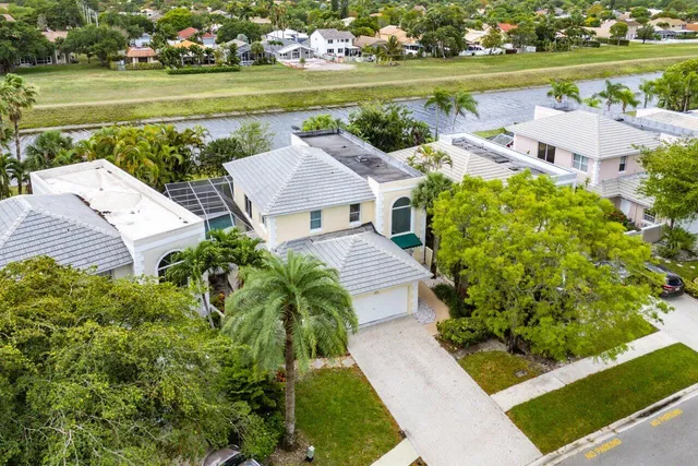 an aerial view of a house with a garden and lake view