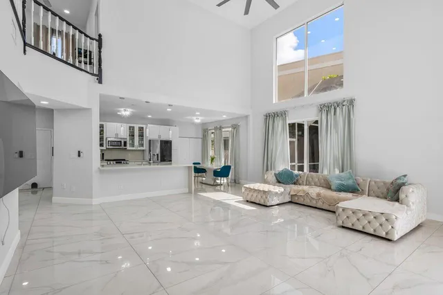 a large white kitchen with stainless steel appliances kitchen island granite countertop a refrigerator and a stove top oven