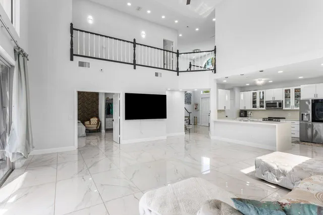a living room with furniture a flat screen tv and a floor to ceiling window