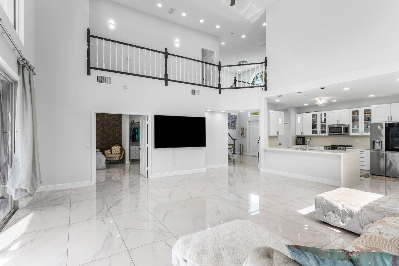 7748 Travelers Tree Drive Boca Raton, FL 33433 - Photo 7 of 35 a large white kitchen with stainless steel appliances kitchen island granite countertop a refrigerator and a stove top oven