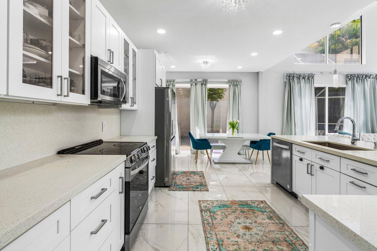 7748 Travelers Tree Drive Boca Raton, FL 33433 - Photo 10 of 35 a kitchen with stainless steel appliances granite countertop a stove and a sink